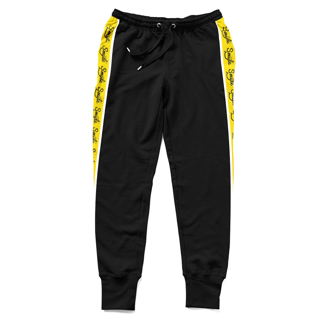 a pair of black and yellow sweat pants with Smyle™ on the sides
